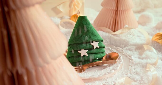 White Christmas table layout with ornaments, decor, and snow.