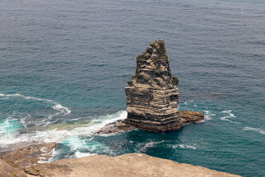 Close-up of An Branan Mor sea stack rock formation surrounded by blue ocean water at Cliffs of Moher, County Clare, Ireland.