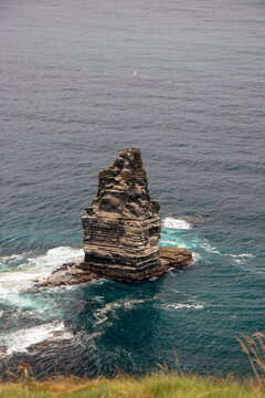 Close-up of An Branan Mor sea stack rock formation surrounded by blue ocean water at Cliffs of Moher, County Clare, Ireland.