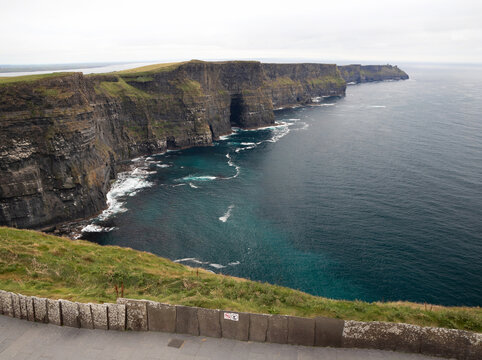 Majestic sea cliffs and turquoise waters of Cliffs of Moher stretching along the Atlantic coastline, County Clare, Ireland.