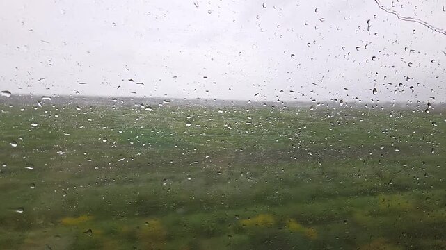 raindrops, train window, rain, rainy window, train journey, raindrops on glass, slow motion, moving train, window, travel, railway travel, rainy day, water drops, droplets, wet glass, blurred landscap