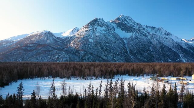 Drone Approach Above Wilderness Woods Revealing Majestic Winter Mountain Range