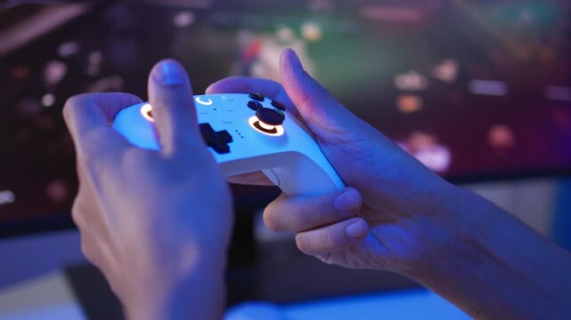 Adult man reacting with game controller during intense gameplay at glowing PC desk, side view with colorful RGB light reflections and focused expression