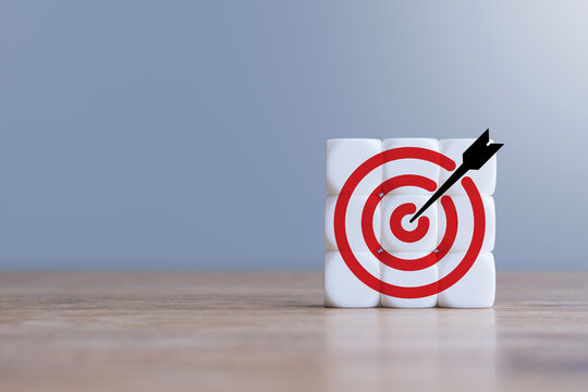 White square blocks with red target and black arrow on wooden table. Business goal, success strategy and achievement concept for marketing and planning.