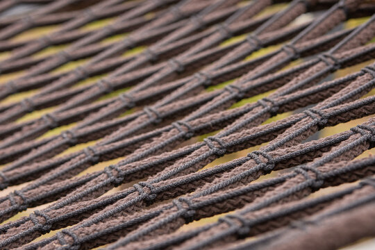 Interwoven dark cords arranged in parallel lines, close up textile texture