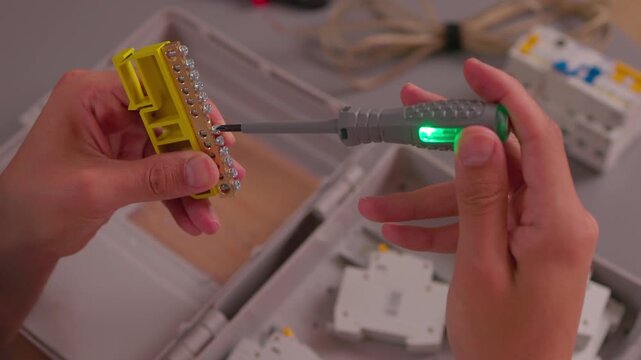 Electrician testing wires with multimeter in control box; close-up industrial style, safety and maintenance concept, ideal for engineering, construction, service, training and technical visuals