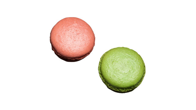 Two colorful french macarons on white surface with pink macaron green macaron sweet treat french pastry baked goods white background round cookies food photography almond cookies snack food