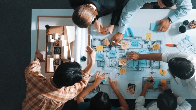 Top aerial view of project manager or civil engineer writing at blueprint and planning building design. Aerial view of architect working together at meeting table with document placed. Alimentation.
