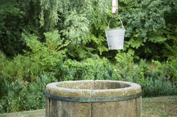 A bucket hanging beside a traditional well with fresh water. © jarizPJ