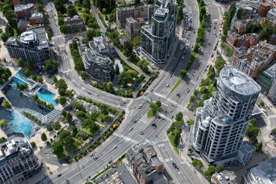 Urban intersection featuring modern architecture and green spaces in a bustling city