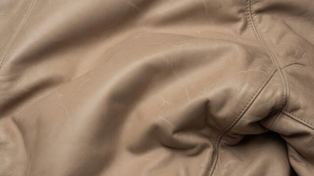 Wrinkled soft beige leather or fabric texture background
