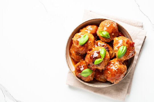 Meatballs in tomato sauce on white background. Top view, close up. Glazed meatballs.
