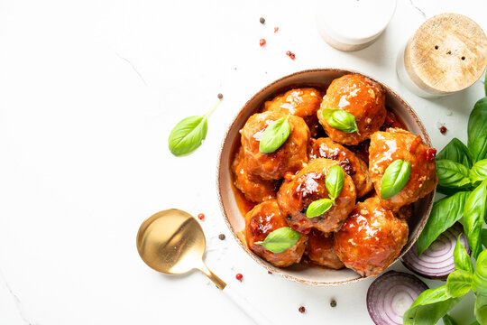 Meatballs in tomato sauce and basil. Top view, close up. Glazed meatballs.