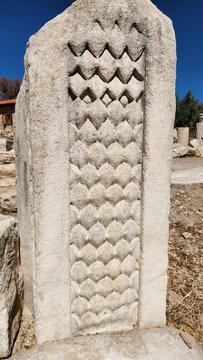  A carved stone pilaster from Stratonikeia Ancient City in Yatağan, Muğla, featuring distinctive fish-scale or diamond-shaped relief patterns and reflecting the cit