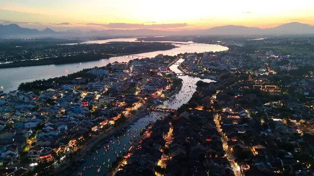 Aerial drone shot of glowing Hoi An river with colorful