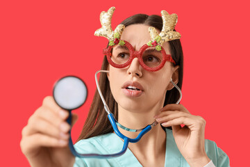Holiday healthcare stress, doctor wearing festive reindeer glasses and scrubs holding a stethoscope for medical examination during the winter season © Pixel-Shot