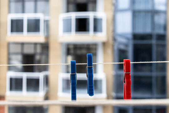 clothespins hang on rope close-up on open balcony