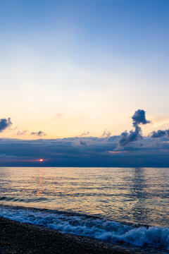 dark sunset sky with clouds and pink setting sun