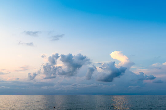 low cumuli cloud in dark blue sky in over calm sea
