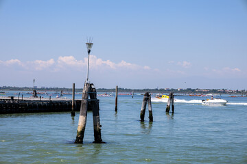 Venice Lagoon with Boats and Wooden Mooring Poles © Julia