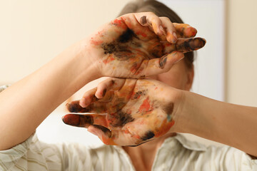 Creativity and artistic expression, woman showing hands covered in colorful paint for creative process, art therapy and hobby inspiration in studio © Pixel-Shot
