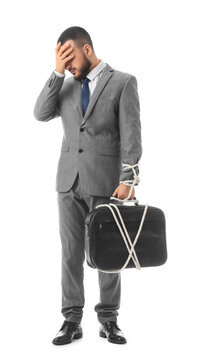 Work stress and professional burnout, businessman tied to briefcase with rope feeling overwhelmed and trapped by corporate career pressure