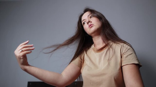 Young woman vigorously moves her hair to create airflow around her head. Slow motion footage shows an improvised attempt to cool down during extreme heat.