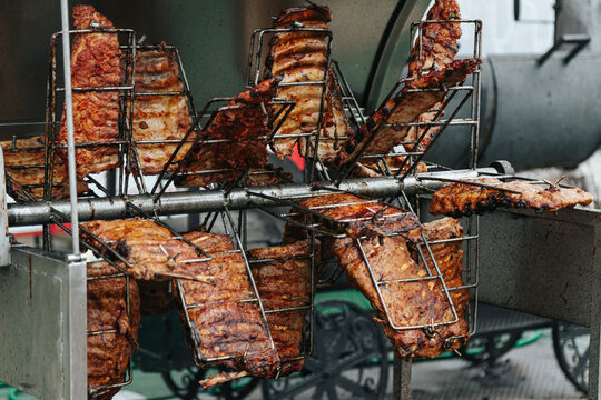 Rotating Metal Baskets Hold Seasoned Ribs Over Open Flames