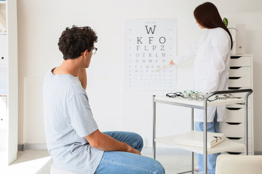 Eye exam and vision test, patient having eyesight checked by optometrist in clinic with eye chart and glasses for medical diagnosis and health care