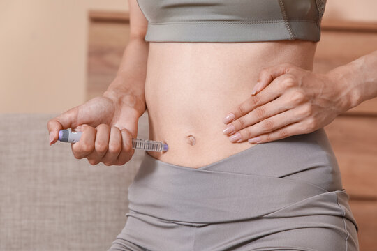 Diabetes management and insulin therapy, woman injecting medication into abdomen with a pen needle for blood sugar control and chronic disease care