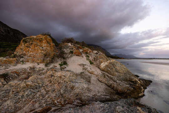 beautiful sunset and dusk light falling upon Grotto lagoon and rock formations, Hermanus, South Africa