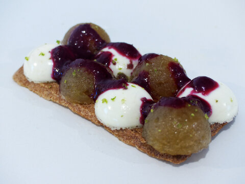 Gourmet panna cotta dessert with fruit compote and hazelnut dacquoise