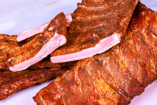 Meat ribs are arranged on ribs are seasoned appear ready for eating.