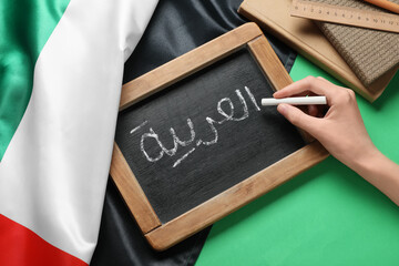 Arabic language learning, student writing on chalkboard with UAE flag for education and cultural studies in the United Arab Emirates © Pixel-Shot