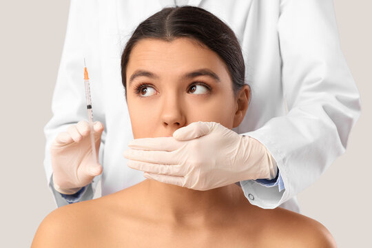 Medical ethics and patient rights, doctor silencing patient with syringe in hand healthcare malpractice and lack of informed consent