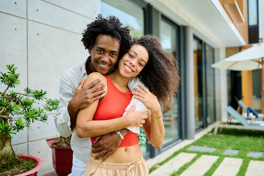 Young couple walking, bonding and enjoying a summer party by a pool, vacation love and bonding concept, luxury villa real estate