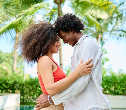 Young couple walking, bonding and enjoying a summer party by a pool, vacation love and bonding concept, luxury villa real estate