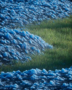 Blue Crystal Rock Formation Meeting Green Grass Aerial View