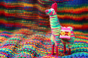 Craft of colorful llama or alpaca with a woven background © Myrarte