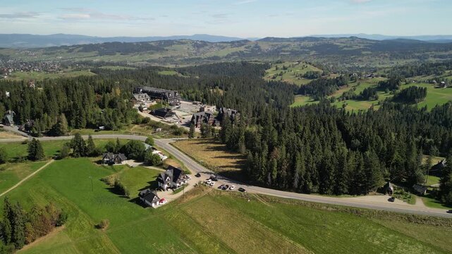 Bukowina Tatrzańska - Polska
Piękny widok na Tatry Wysokie nagrany dronem w słoneczny dzień. G&oacute;ry, chmury, słońce, pola, droga g&oacute;rska, las, Podhale.