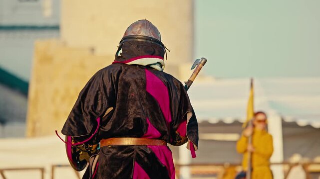 Armored knight dodges heavy strike during medieval buhurt combat.