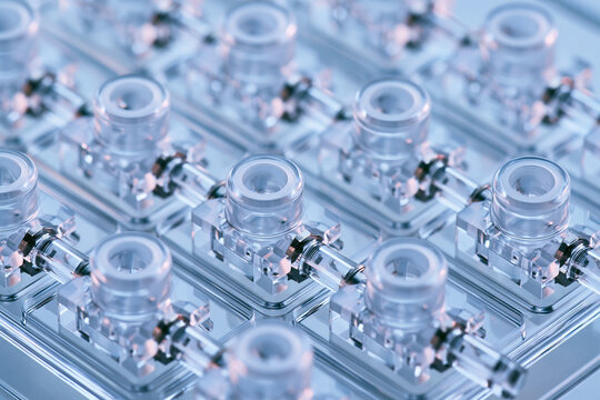 Transparent laboratory microfluidic chip array on bright white background with laboratory equipment scientific research transparent plastic fluidic channels biotech device laboratory technology