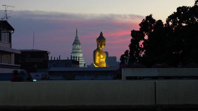 Giant Golden Buddha statue at Wat Paknam Phasi Charoen temple at sunset in Bangkok, large tall Buddha monument called Phra Buddha Dhammakaya Thep Mongkol and Maharatchamongkhon Stupa in Thailand.