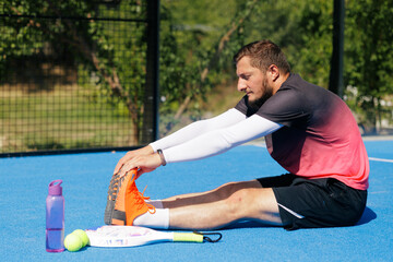 Obraz premium Padel Player Stretching Before Match for Sports Injury Prevention