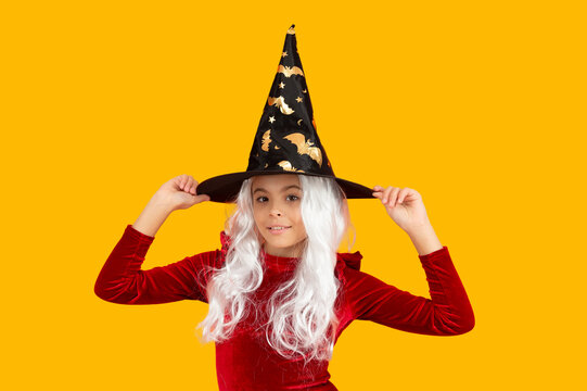 Girl in Halloween witch costume. Happy Halloween. Girl witch in Halloween costume isolated on yellow. Trick or treat. All Hallows costume party celebration. All Hallows witch