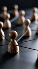 Obraz premium Wooden figurines connected by fine strings representing networking, communication, and social connections on a dark surface in concept of teamwork