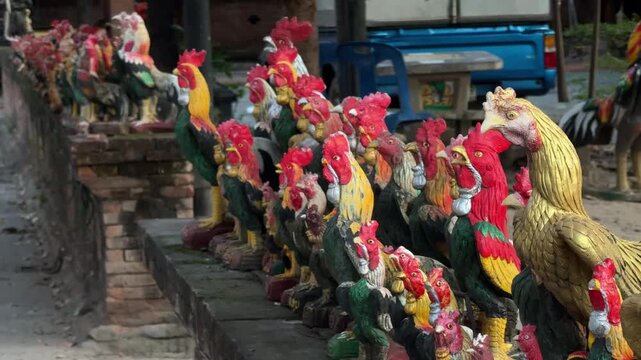Rooster statues lined up at temple shrine in Chiang Mai
