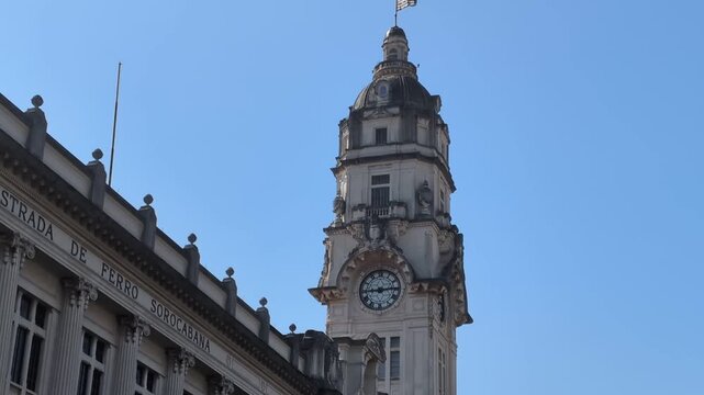 Static 4K 60fps shot of the historic Julio Prestes Station clock tower against a clear blue sky in downtown Sao Paulo, Brazil. Beautiful eclecticism architecture.
