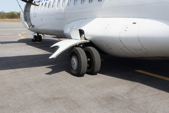 Detail of aircraft landing gear and tires on the runway at an airport