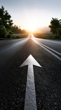 Empty asphalt road with forward arrow marking leading toward bright sunrise surrounded by trees and open landscape on both sides